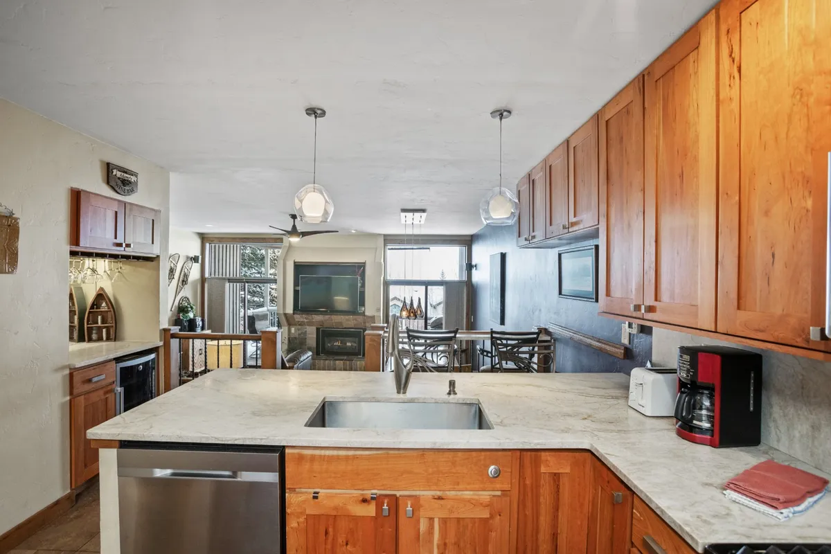 A spacious kitchen and open layout with modern appliances and large windows letting in abundant natural light. The view beyond the windows hints at the vibrant outdoor setting, suggesting easy transitions from preparing meals indoors to enjoying activities outside.